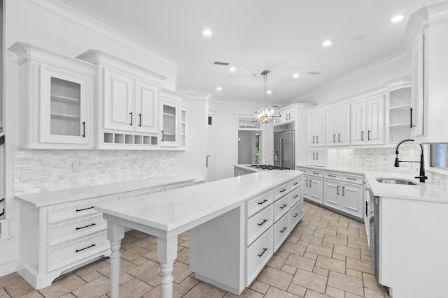 kitchen featuring high end fridge, a sink, open shelves, a center island, and white cabinetry