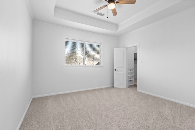 unfurnished room featuring visible vents, crown molding, ceiling fan, light colored carpet, and a tray ceiling