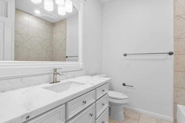 full bathroom featuring vanity, baseboards, a tub, tile patterned floors, and toilet