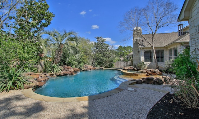 view of pool featuring a patio area, a pool with connected hot tub, and fence