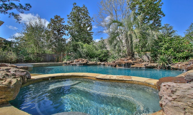 view of pool featuring an in ground hot tub, fence, and a fenced in pool