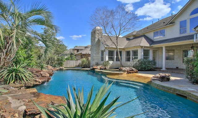 outdoor pool with an in ground hot tub, fence, and a patio