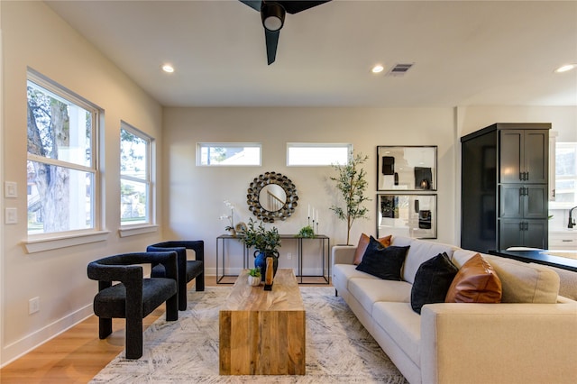 living area featuring recessed lighting, visible vents, light wood-style flooring, and baseboards