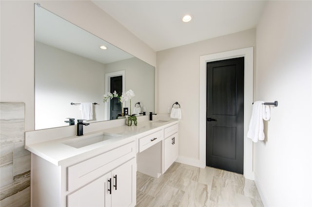 bathroom featuring a sink, recessed lighting, and double vanity