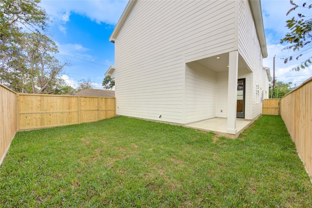 rear view of property featuring a fenced backyard, a patio area, and a yard