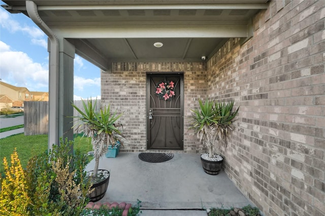 view of exterior entry featuring brick siding