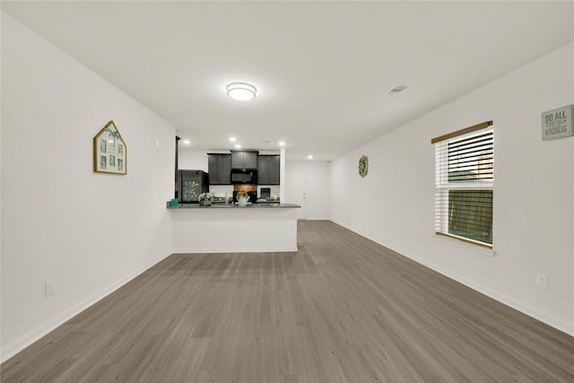 unfurnished living room featuring visible vents, recessed lighting, baseboards, and wood finished floors