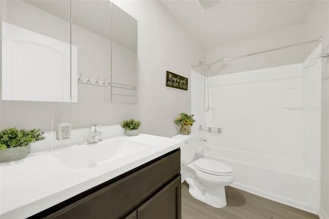 bathroom with vanity, wood finished floors, visible vents, toilet, and shower / bathtub combination