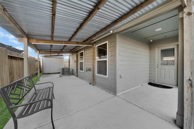 view of patio featuring a storage unit, an outbuilding, cooling unit, and fence