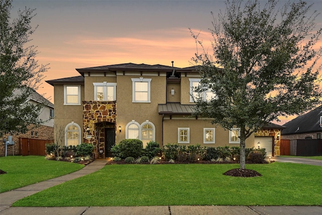 view of front of house featuring fence, stucco siding, a garage, a yard, and driveway