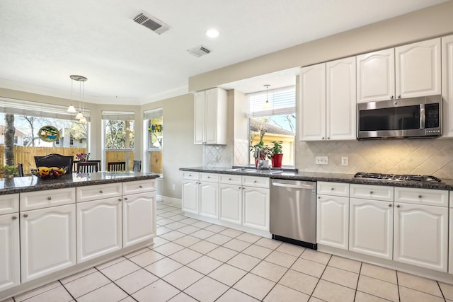 kitchen with backsplash, visible vents, appliances with stainless steel finishes, and pendant lighting