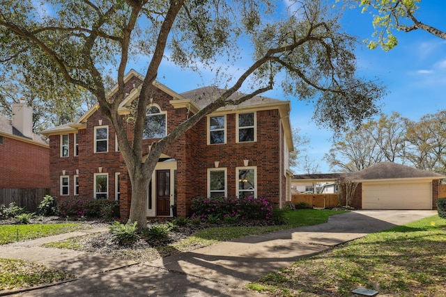 traditional-style house featuring brick siding, concrete driveway, a garage, and fence