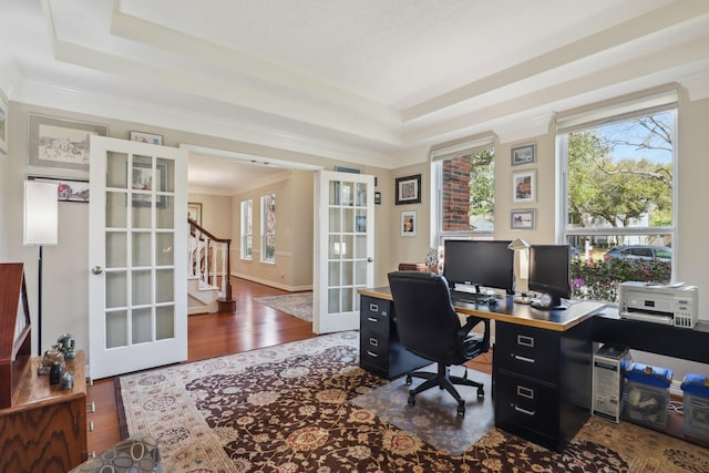 office with a tray ceiling, wood finished floors, and french doors