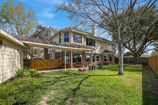 rear view of house with a gate, brick siding, a fenced backyard, a patio area, and a lawn