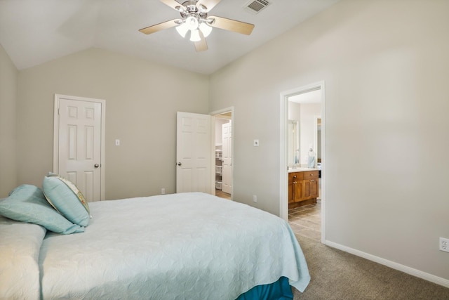 bedroom with visible vents, light carpet, connected bathroom, baseboards, and vaulted ceiling