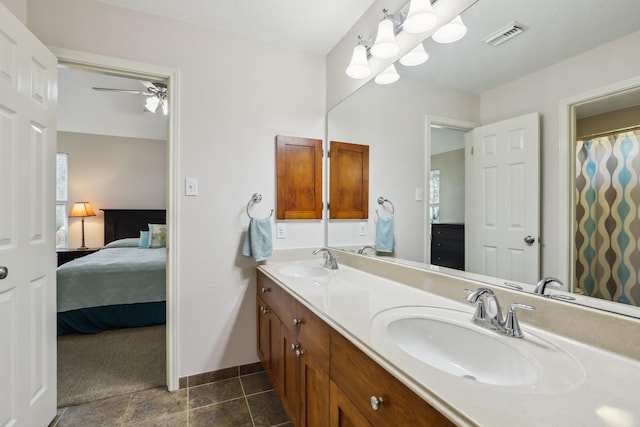 ensuite bathroom with double vanity, connected bathroom, visible vents, and a sink