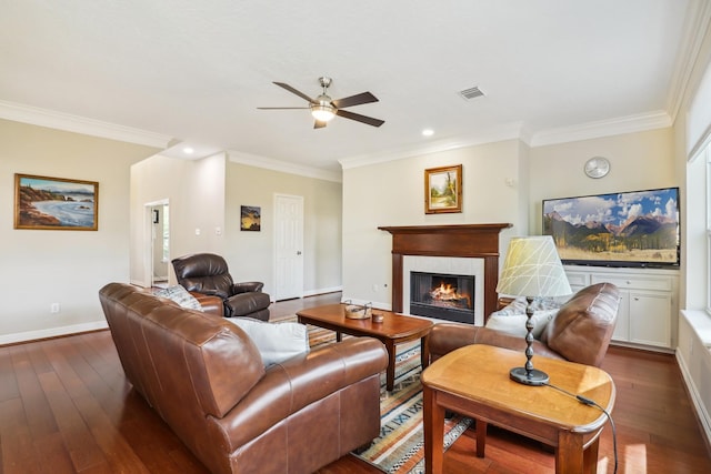 living area featuring dark wood finished floors, visible vents, a tiled fireplace, and ceiling fan