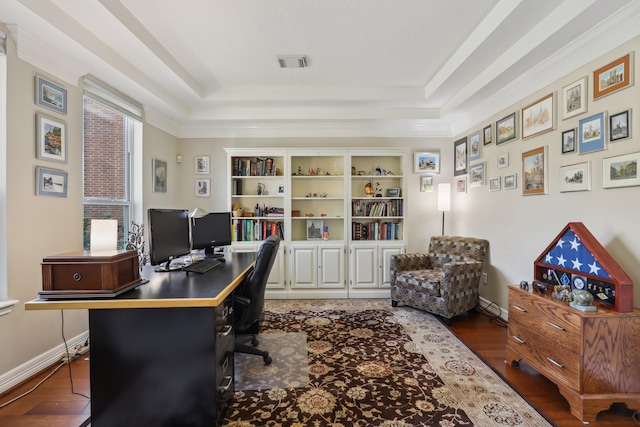 office area featuring a tray ceiling, wood finished floors, visible vents, and baseboards