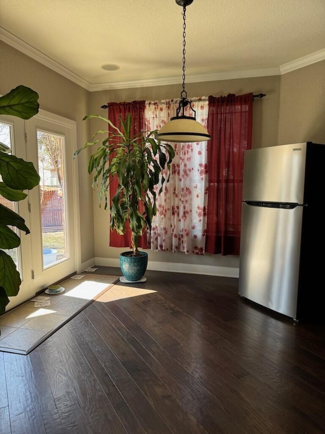 unfurnished dining area featuring ornamental molding, baseboards, and hardwood / wood-style flooring