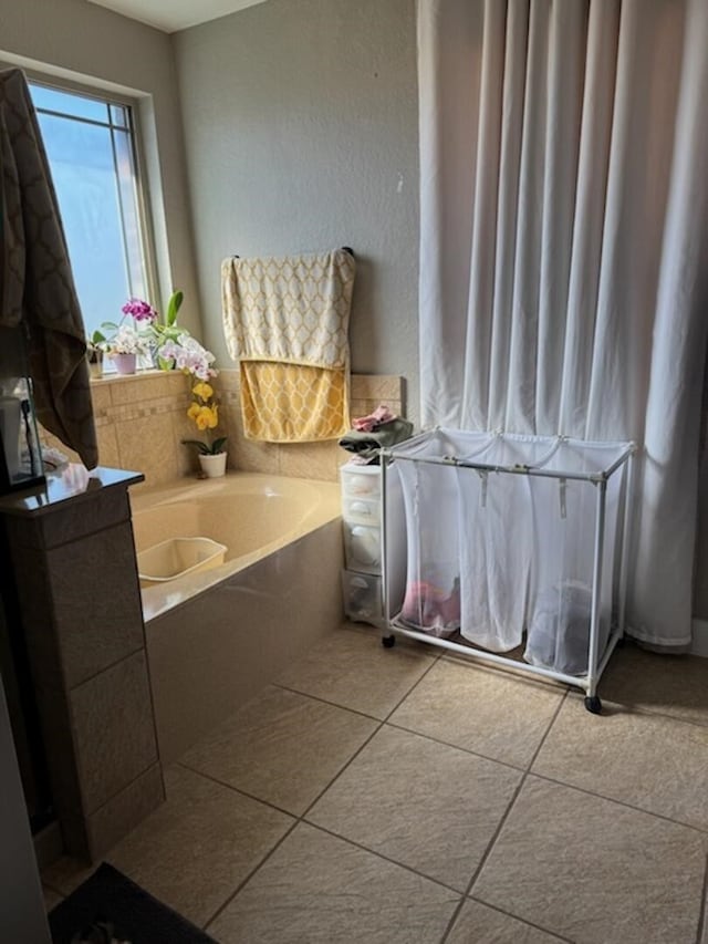 bathroom with tile patterned floors and a bath