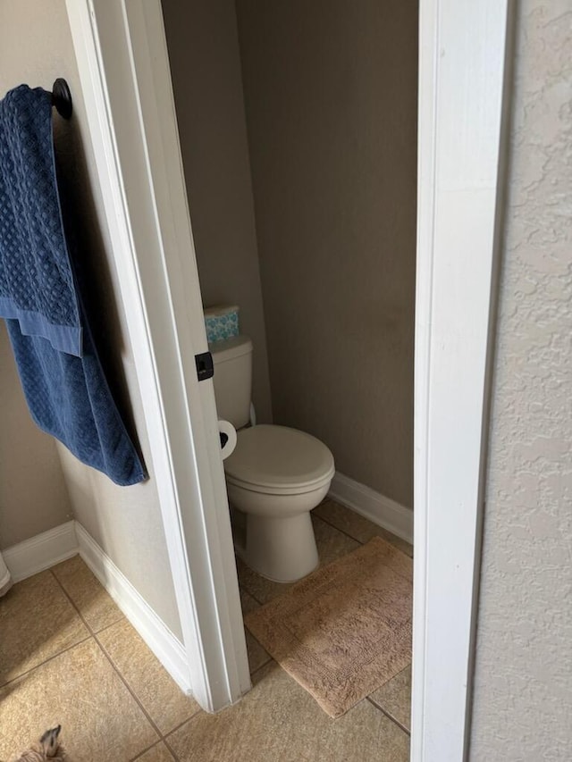 bathroom featuring tile patterned floors, baseboards, and toilet