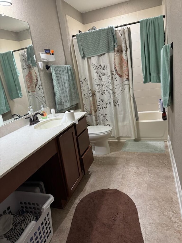 full bath featuring toilet, shower / bath combo, vanity, and a textured wall