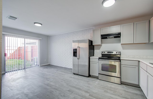 kitchen with visible vents, gray cabinetry, light countertops, under cabinet range hood, and appliances with stainless steel finishes