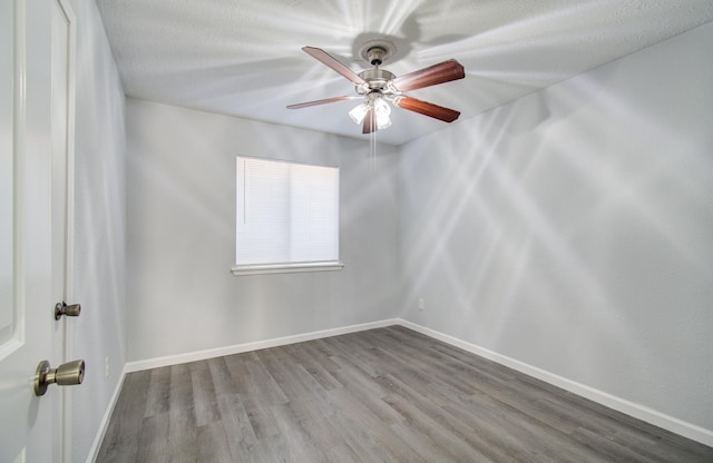 unfurnished room featuring a textured ceiling, a ceiling fan, baseboards, and wood finished floors