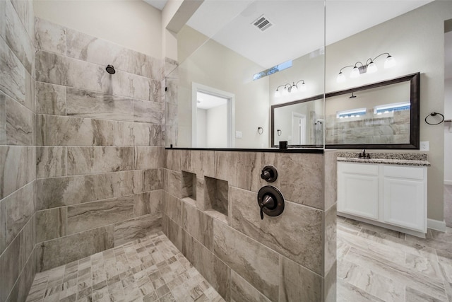 bathroom featuring visible vents, vanity, and walk in shower