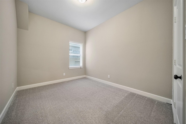 empty room featuring carpet flooring and baseboards