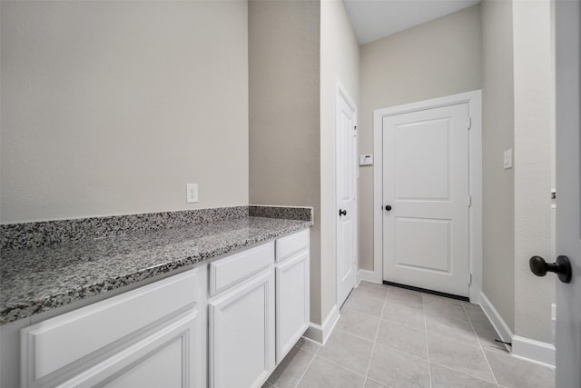 laundry room with light tile patterned flooring and baseboards