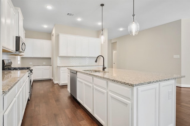 kitchen featuring visible vents, stainless steel appliances, a sink, dark wood-type flooring, and white cabinets