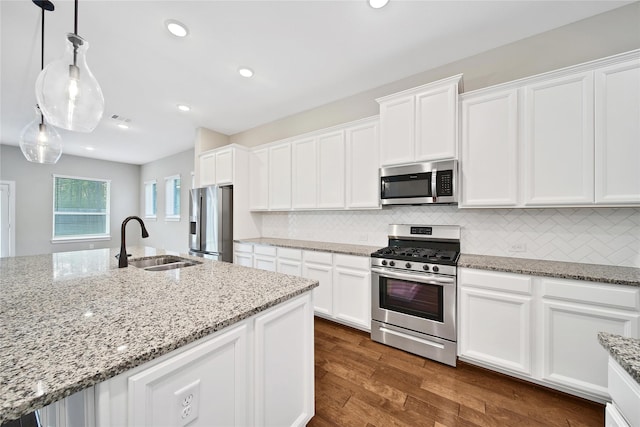 32193 Park Plains Dr, Conroe, TX 77385 - kitchen with appliances with stainless steel finishes, a sink, white cabinets, and recessed lighting