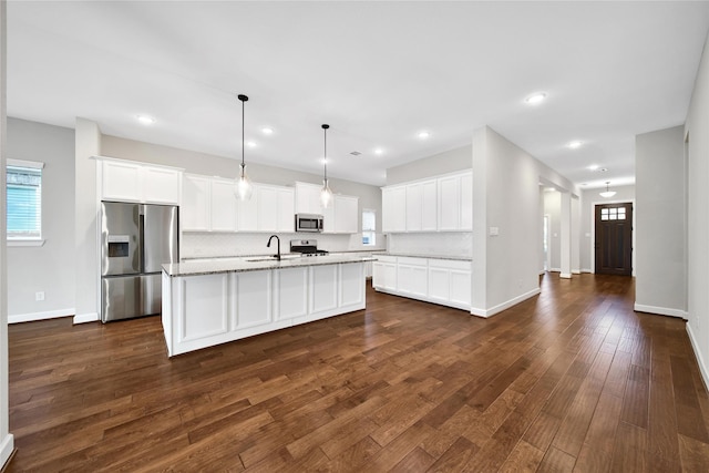 32193 Park Plains Dr, Conroe, TX 77385 - kitchen featuring appliances with stainless steel finishes, healthy amount of natural light, dark wood finished floors, a sink, and recessed lighting