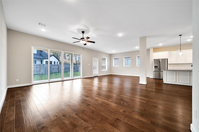 32193 Park Plains Dr, Conroe, TX 77385 - unfurnished living room featuring dark wood-style flooring, healthy amount of natural light, ceiling fan, baseboards, and recessed lighting