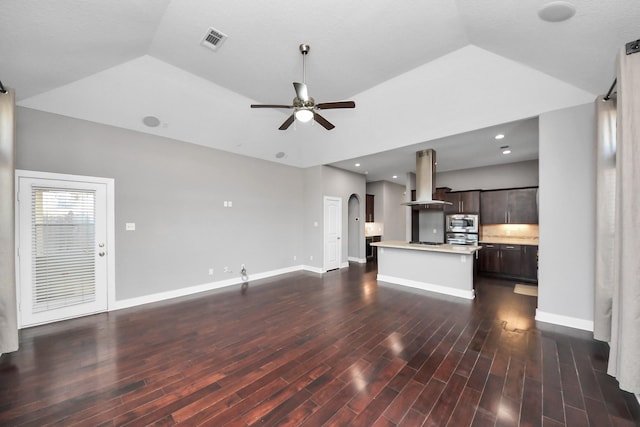 unfurnished living room featuring arched walkways, visible vents, a ceiling fan, and dark wood-style floors