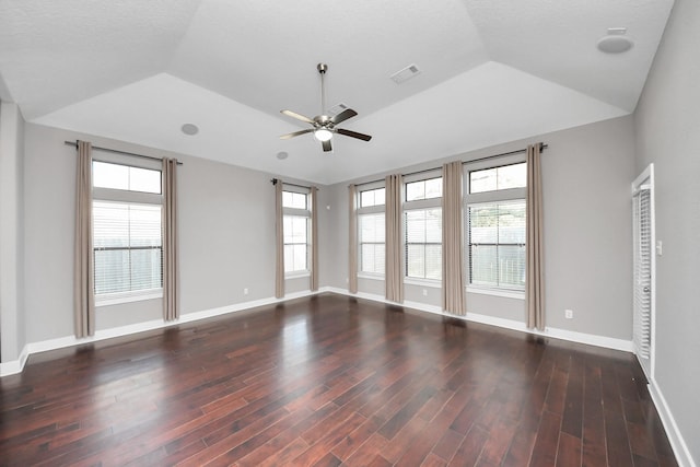 spare room with baseboards, ceiling fan, a tray ceiling, vaulted ceiling, and wood finished floors