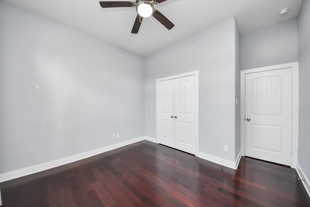 unfurnished bedroom featuring ceiling fan, a closet, baseboards, and wood finished floors