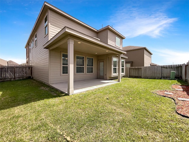 rear view of house with a fenced backyard, a lawn, and a patio