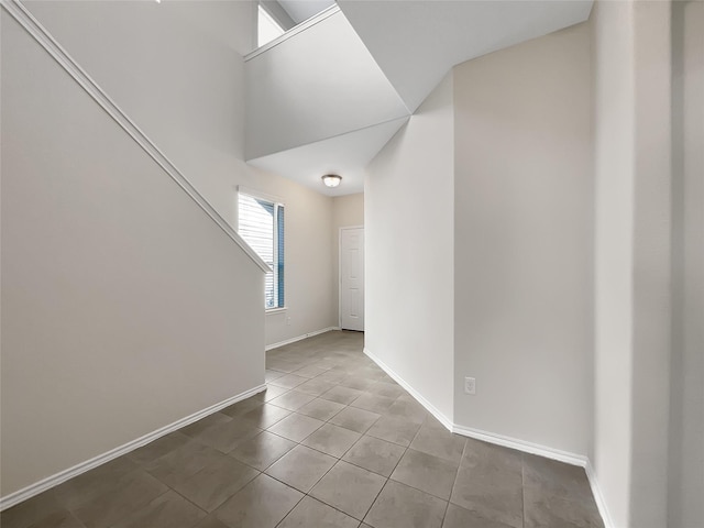 empty room with baseboards, stairs, and tile patterned flooring