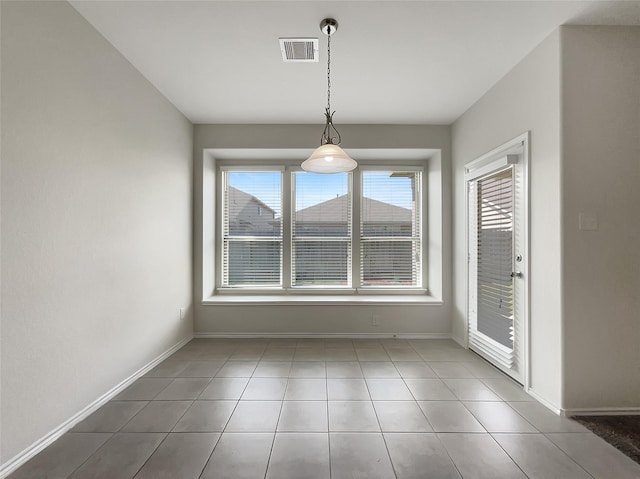 unfurnished dining area with tile patterned floors, visible vents, and baseboards