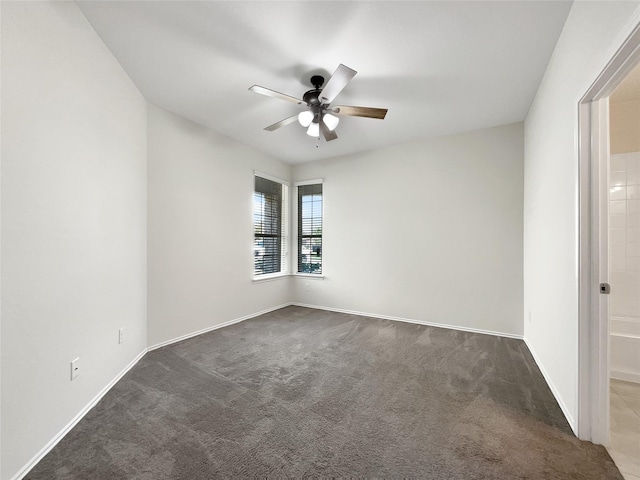 carpeted empty room featuring baseboards and ceiling fan