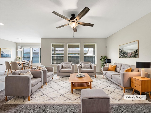 living room featuring baseboards and a ceiling fan