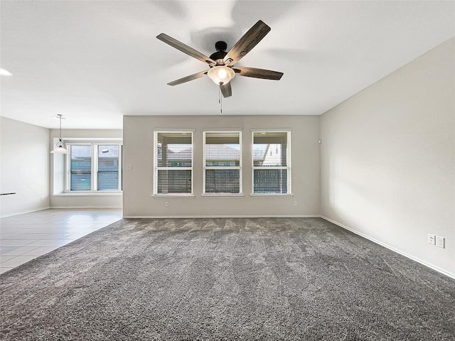 unfurnished room featuring tile patterned flooring, carpet flooring, baseboards, and ceiling fan