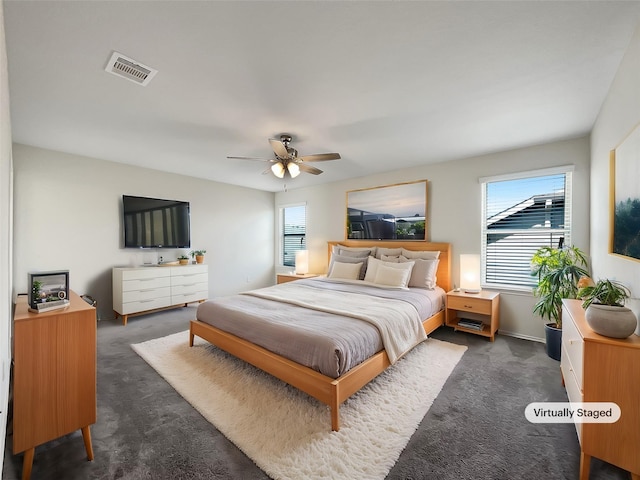 bedroom featuring visible vents, a ceiling fan, and dark colored carpet