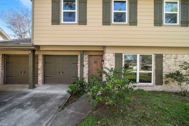 view of property with brick siding and driveway