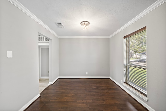 empty room with visible vents, an inviting chandelier, wood finished floors, and ornamental molding