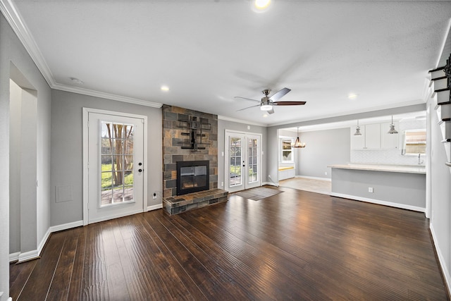 unfurnished living room featuring hardwood / wood-style flooring, ornamental molding, a fireplace, and ceiling fan