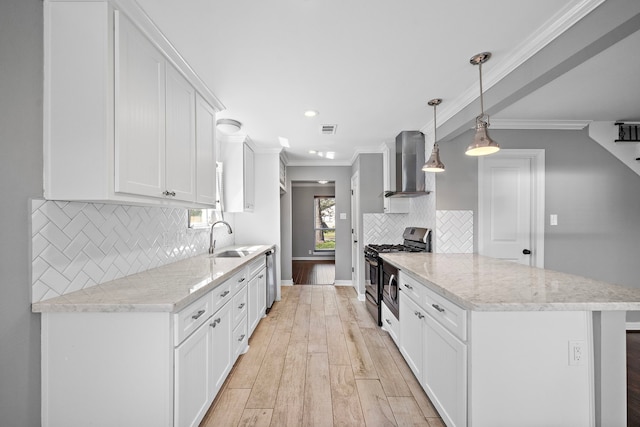 kitchen with wall chimney range hood, light wood-type flooring, ornamental molding, appliances with stainless steel finishes, and a sink