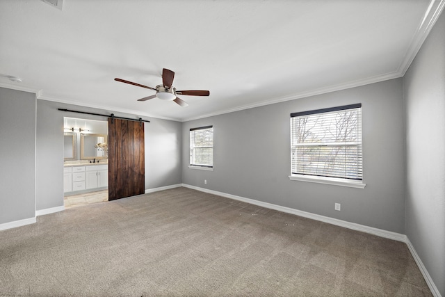 unfurnished bedroom with a barn door, light carpet, baseboards, and ornamental molding